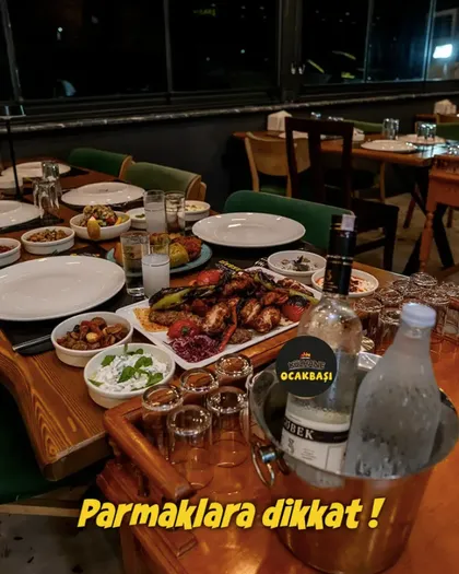Gece dolu bir masa; ocaktan gelen tabaklar ve kalabalık sofra